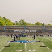 Aerial view of GVSU employees playing cornhole against one another on the football field in Lubbers Stadium